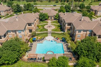 An aerial view of a swimming pool surrounded by houses.